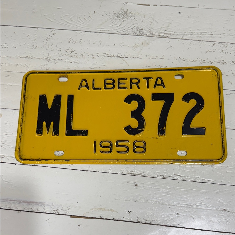 This is a vintage Alberta yellow and black license plate 1958